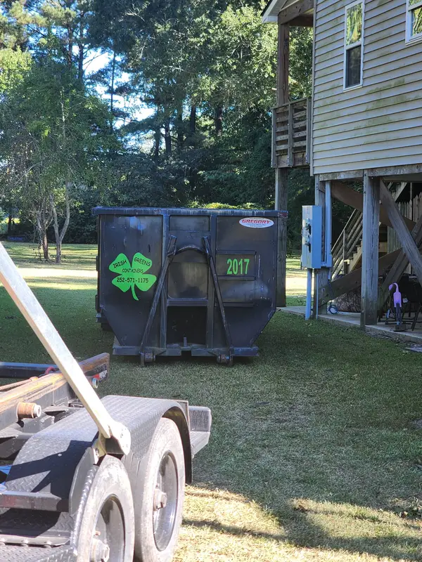 Irish Greens container 2017 on the grass beside a raised house